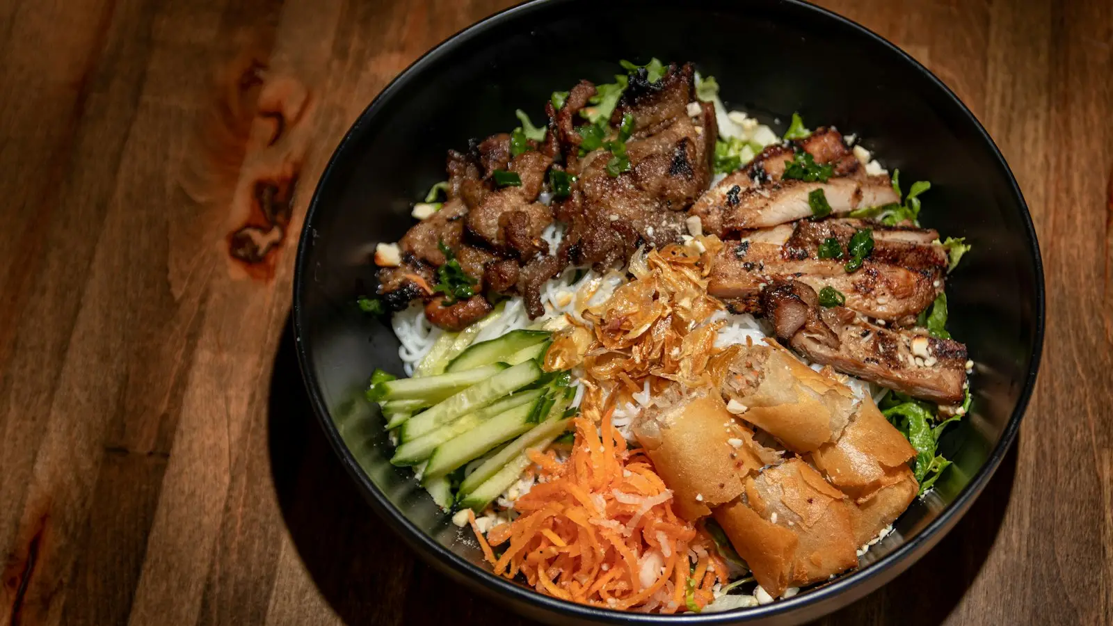 A bowl of sliced grilled meat with rice and vegetables